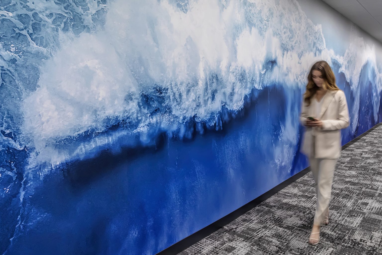 Woman walks by an ocean wall graphic
