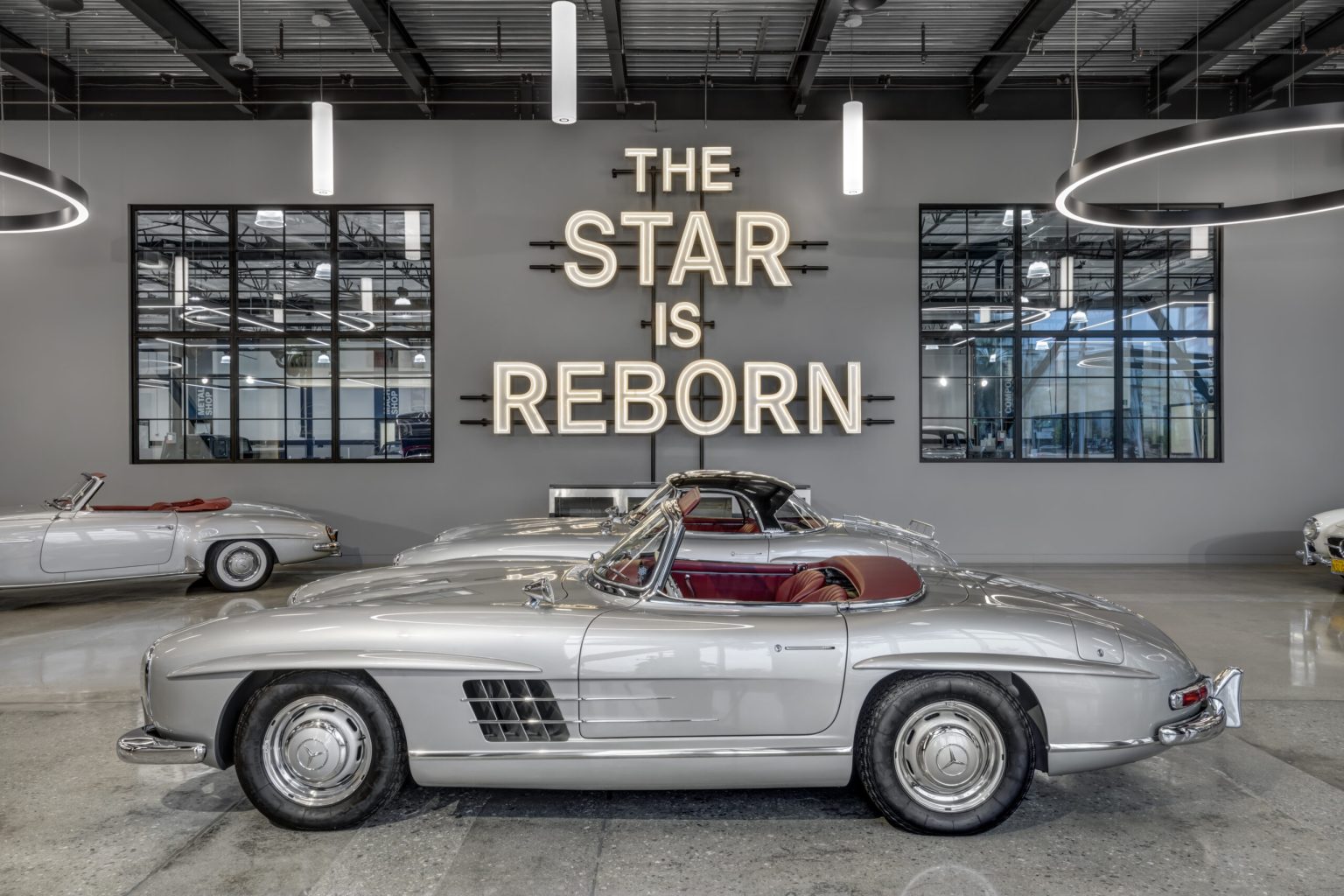 Commercial interior design for automotive showroom by Hendy — vintage Mercedes display with custom neon signage, California