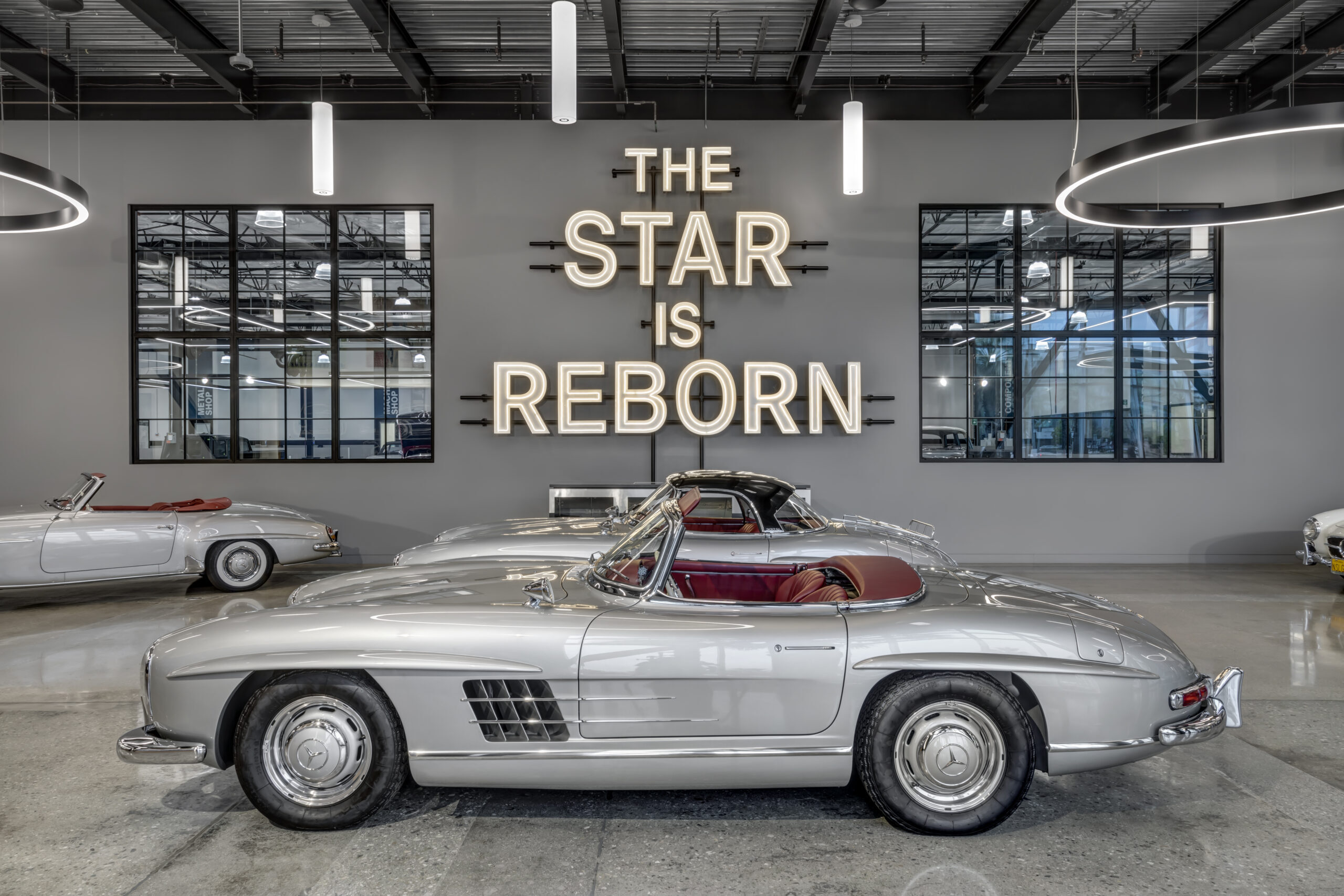 Commercial interior design for automotive showroom by Hendy — vintage Mercedes display with custom neon signage, California